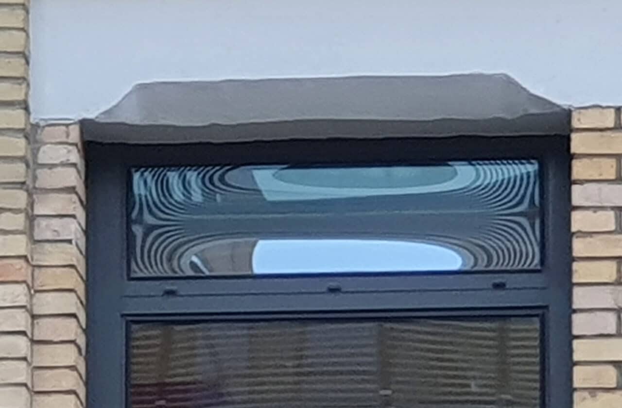 Façade vitrée d'un immeuble dont les vitres soint déformées par les lames de gaz